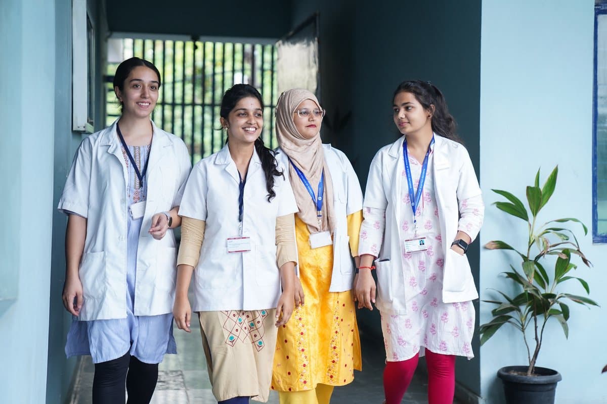 Pharmacy students in lab coats walking through campus