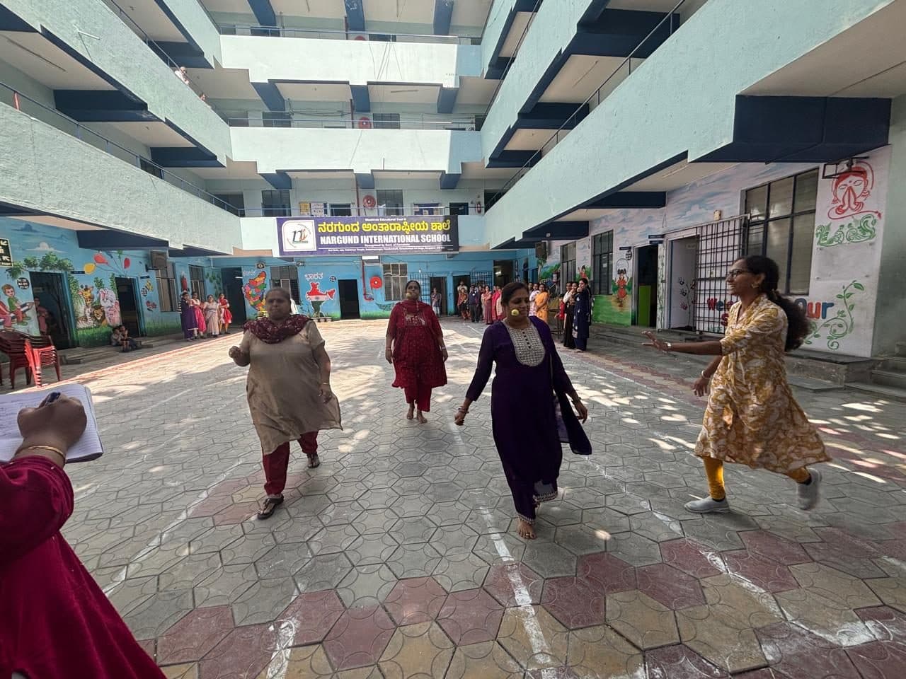 Mothers taking part in a race in the courtyard