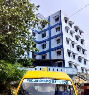 The boys' hostel building with the college bus in front