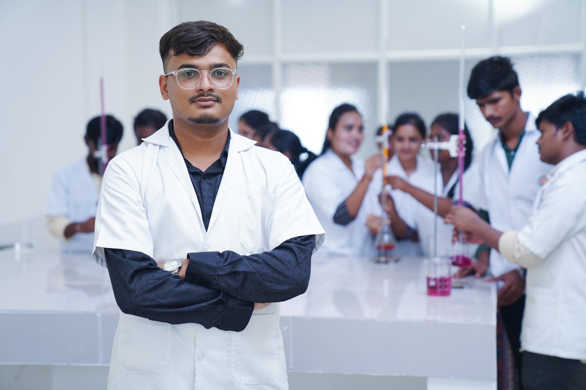 A degree student in a lab coat in the science lab
